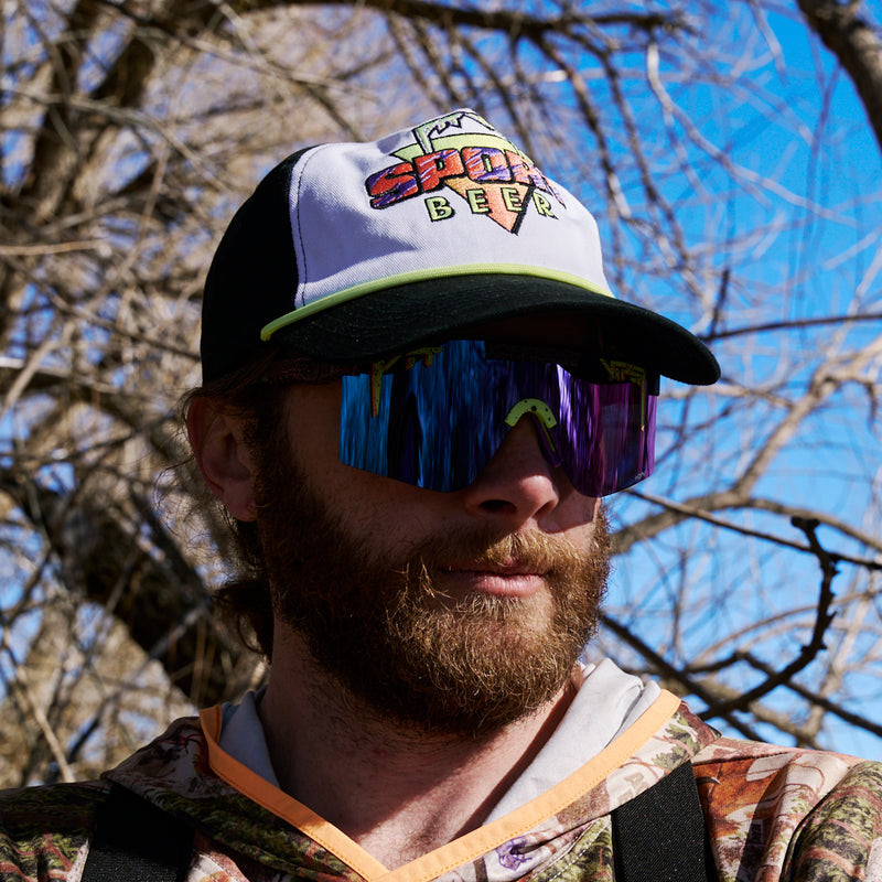  | photo_of_person.JPG | Person wearing the person wearing the Sport Beer Dangerfield Hat from Pit Viper in the woods.