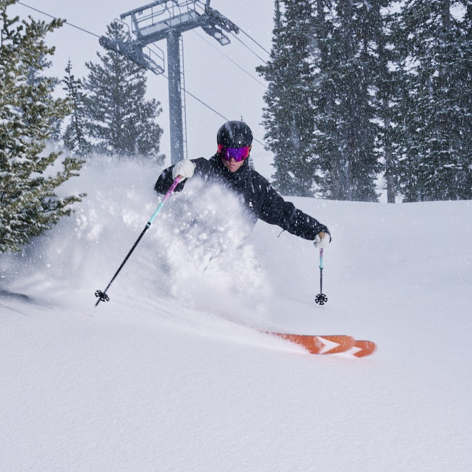man skiing in deep snow wearing pit viper brand goggles and helmet